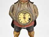 une statue représentant un homme tenant une horloge entre ses mains