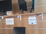 a laptop and a monitor on a shelf in a room