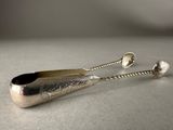 silver plated spoon and spoon rest on a white surface