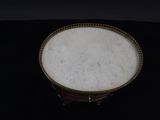a small white plate with a gold rim on a black table