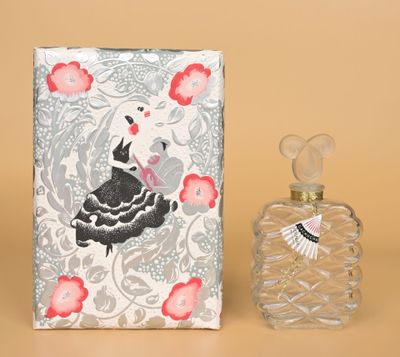 un petit flacon de parfum à côté d'une petite boîte