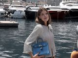 une femme debout sur un quai, une valise à la main