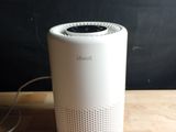 a white air purifier sitting on a wooden table