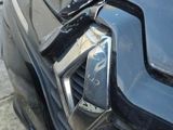 a close up of a car ' s front bumper with a denting on it