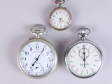 two silver pocket watches sitting next to each other on a white surface