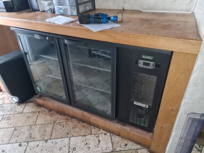 a refrigerator with a glass door sitting on a counter
