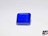 un gros plan d'un objet bleu de forme carrée posé sur une surface blanche