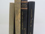 trois livres superposés sur une surface blanche