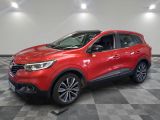 une voiture rouge est garée dans une pièce au sol en damier