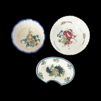 trois assiettes ornées de motifs floraux et de feuilles sur fond noir