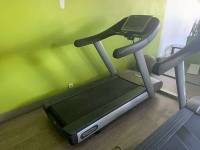 un tapis de course dans un coin d'une pièce aux murs verts