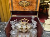 bottles and glasses in a wooden case sitting on a table