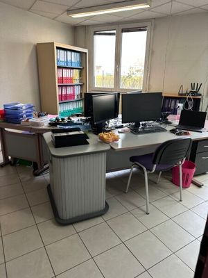 un bureau avec deux ordinateurs et une chaise dans une pièce