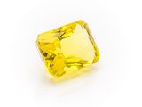 a yellow sapphire stone on a white background