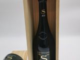 une bouteille de vin dans un coffret en bois, à côté d'une tasse