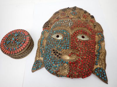 une image représentant un masque décoratif orné d'un visage rouge et bleu