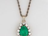 an emerald and diamond pendant on a chain