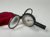 a magnifying glass and a red velvet pouch on the table