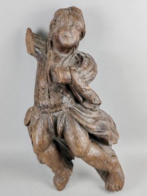 statue of a boy sitting on a tree branch holding a bag
