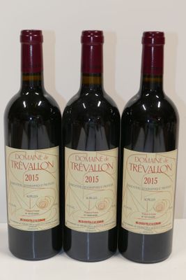 trois bouteilles de vin rouge sont alignées sur une table