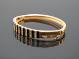 a close up of a gold ring on a reflective surface