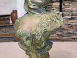 a statue of a woman holding a flower on a table
