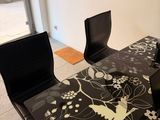 a black and white table with chairs and a clock on the wall