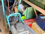 un diable bleu avec une poignée verte dans un garage