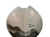 a white and black vase with birds flying in the sky