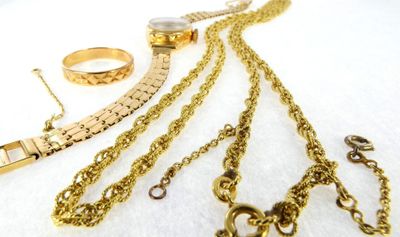 a lot of gold jewelry on a white surface