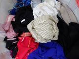 a basket full of clothes that is sitting on a bed