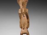 une image représentant une statue en bois d'un homme sur un socle