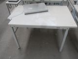 une table blanche sur laquelle est posé un ordinateur portable