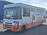 un camion blanc et orange garé sur un parking