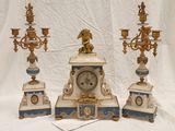 three clocks and three candeliers sitting on a table