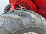 a large red tractor with a big tire on the side of it