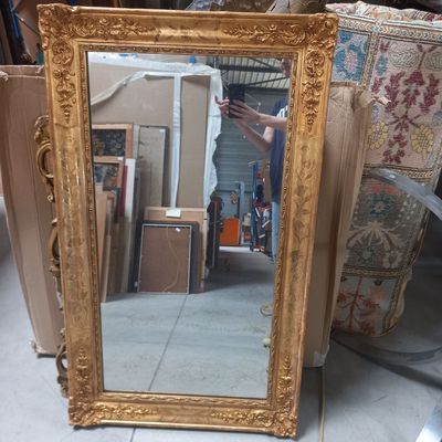 un miroir posé par terre à côté d'un canapé