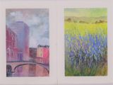 deux tableaux représentant des bâtiments et un pont dans un champ d'herbes hautes