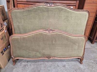 un lit avec une tête et un pied de lit dans une chambre