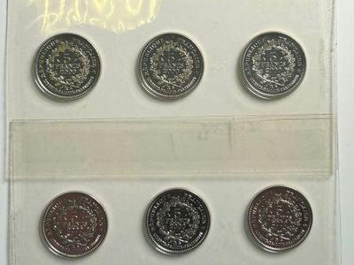 six pièces différentes dans une vitrine posée sur une surface blanche