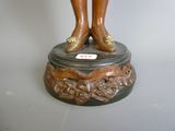 a bronze statue of a woman standing on top of a pedestal