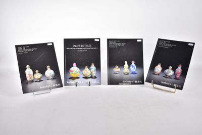 quatre livres posés sur une surface blanche, sur fond blanc