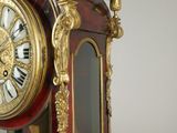 a red and gold clock sitting on top of a table