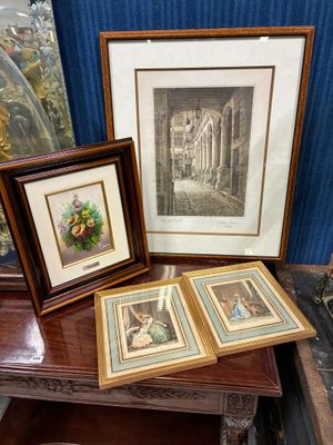 trois photos encadrées posées sur une table, à côté d'une lampe