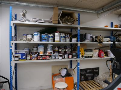 a garage with a lot of paint and tools on the shelves