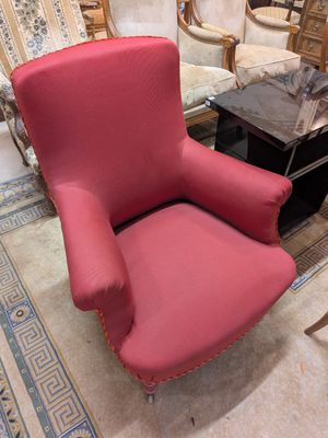 un fauteuil rouge dans un salon avec une table basse
