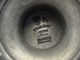 a close up of a silver vase with a black label