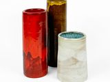 trois vases posés l'un à côté de l'autre sur une surface blanche