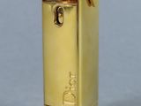 une photo d'un briquet doré posé sur une table blanche