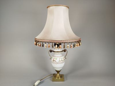 une lampe posée sur une table, avec un abat-jour blanc